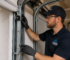 Technician inspecting garage door cable, roller and track system